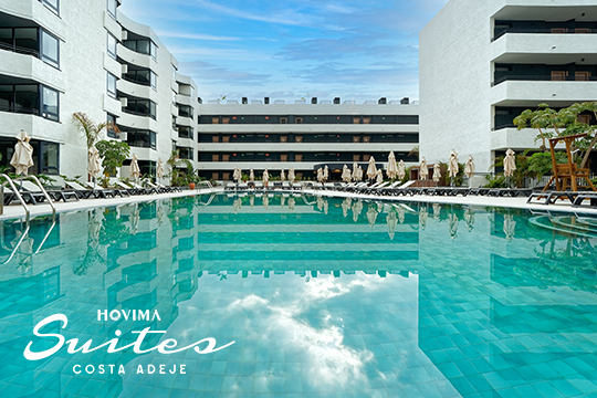 Hotelpool im Vordergrund, rechts und links Hotelgeb&auml;ude in wei&szlig;